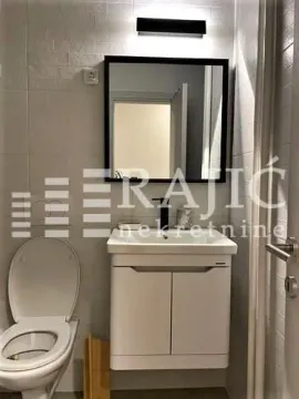 Small bathroom with a sink, mirror, and toilet bowl. - image 4