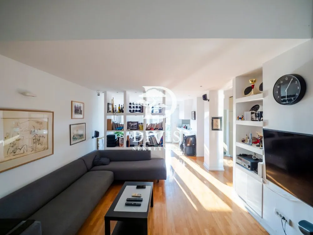 Living room with a corner sofa, shelving units and a TV.