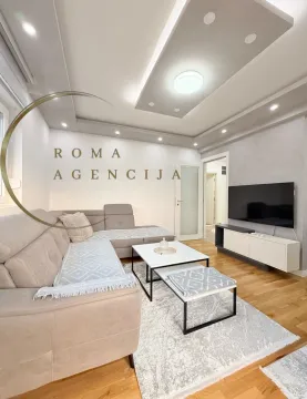 Modern and tidy living room with a sectional sofa and television. - image 2