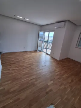 Empty room with wooden flooring, air conditioning unit, and balcony doors. - image 11