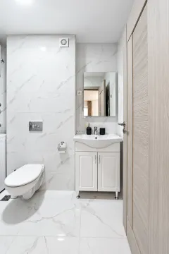 Moderne kupatilo sa bijelim pločicama, umivaonikom i toaletom. - image 12