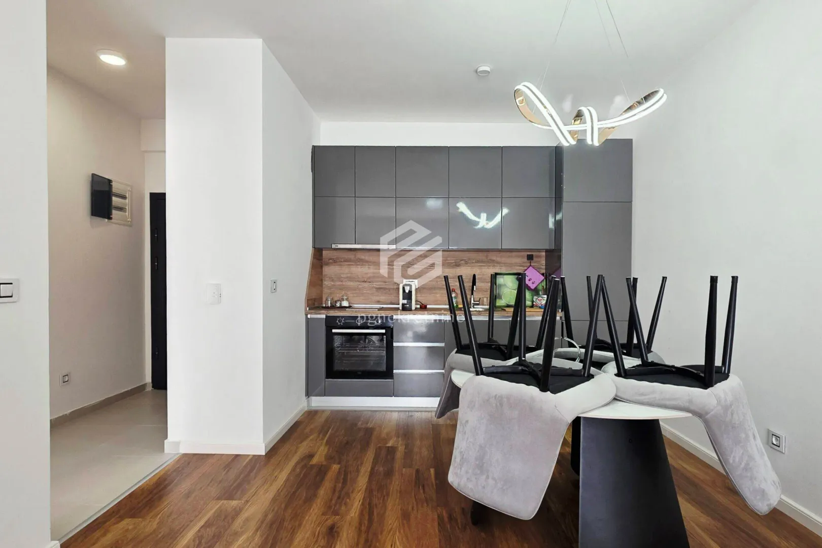 Modern kitchen with grey cabinets and a dining table.