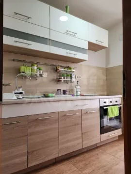 Smaller kitchen with wooden lower cabinets and white upper cabinets. - image 3