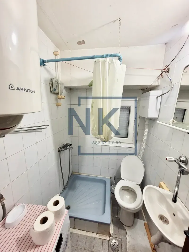 Manje kupatilo sa tuš kabinom, WC šoljom i umivaonikom.