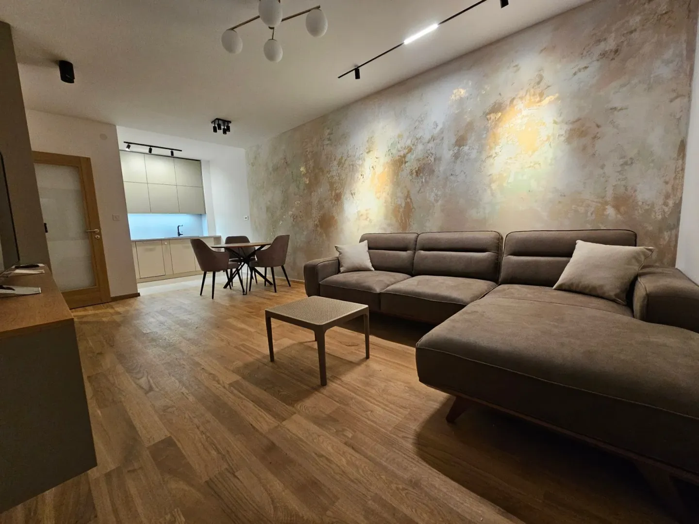 Modern living room with a sectional sofa and a dining area in the background.