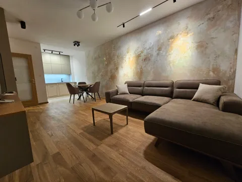 Modern living room with a sectional sofa and a dining area in the background. - image 2