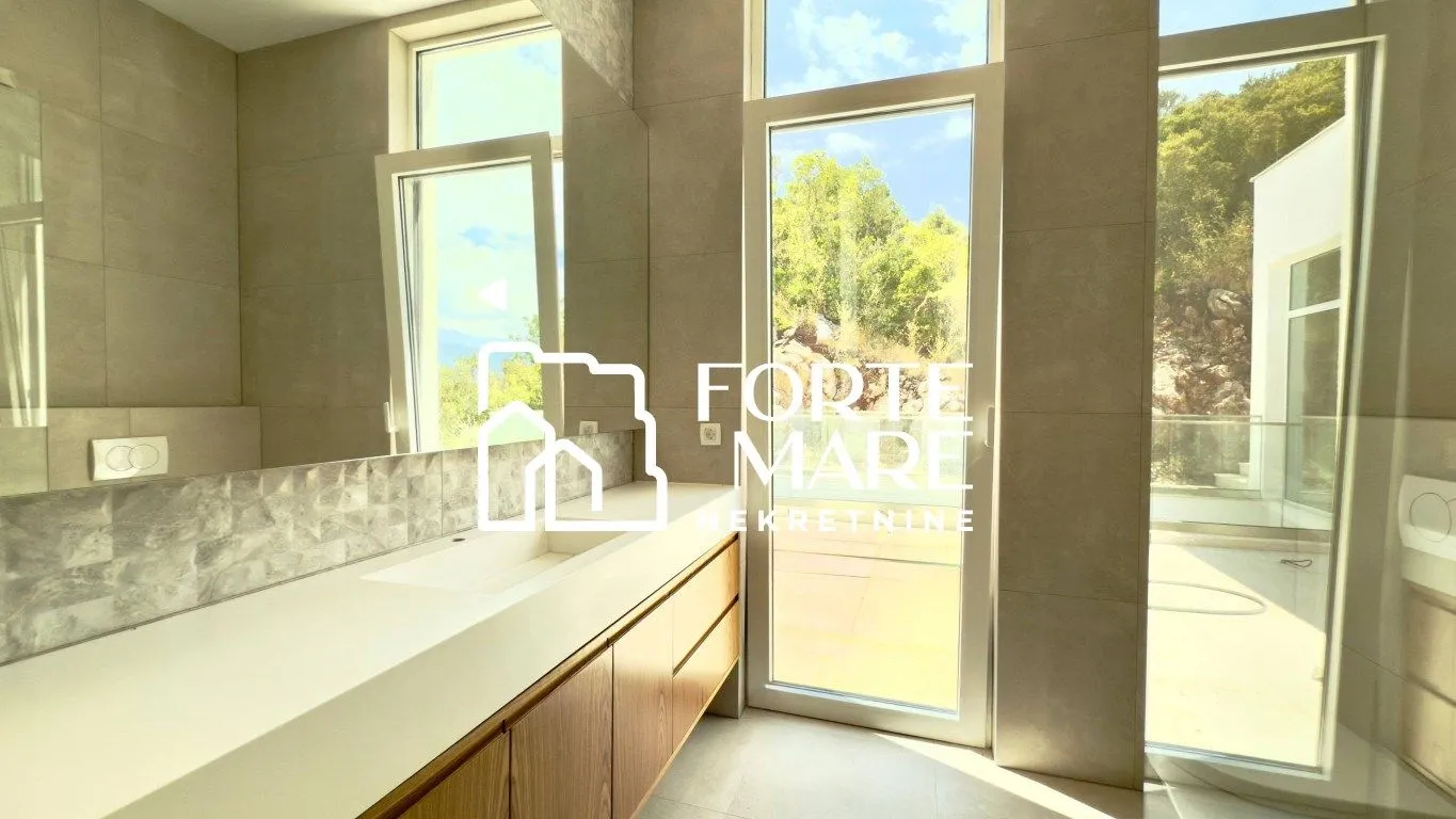 Modern bathroom with a large vanity and access to the terrace.