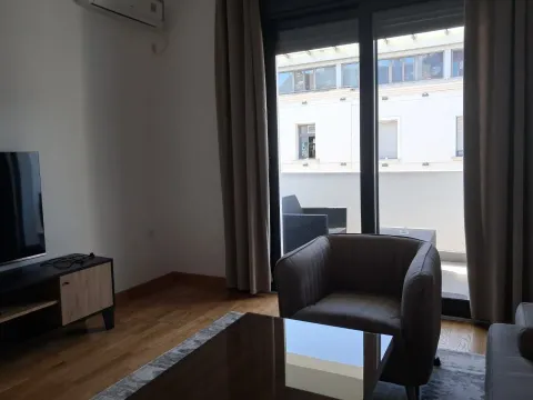 Living room with an armchair, television, and terrace access. - image 5