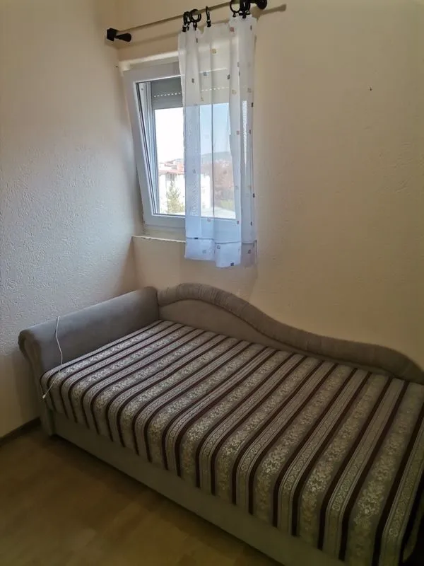 Manja spavaća soba sa krevetom i prozorom.