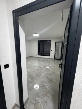 View through the doorway into an empty room with tiled flooring. - image 11