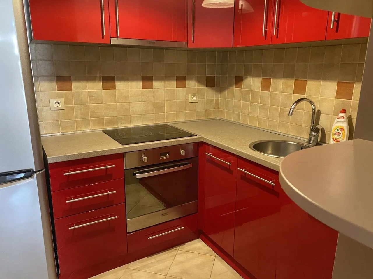 Functional kitchen with red cabinets and integrated appliances.