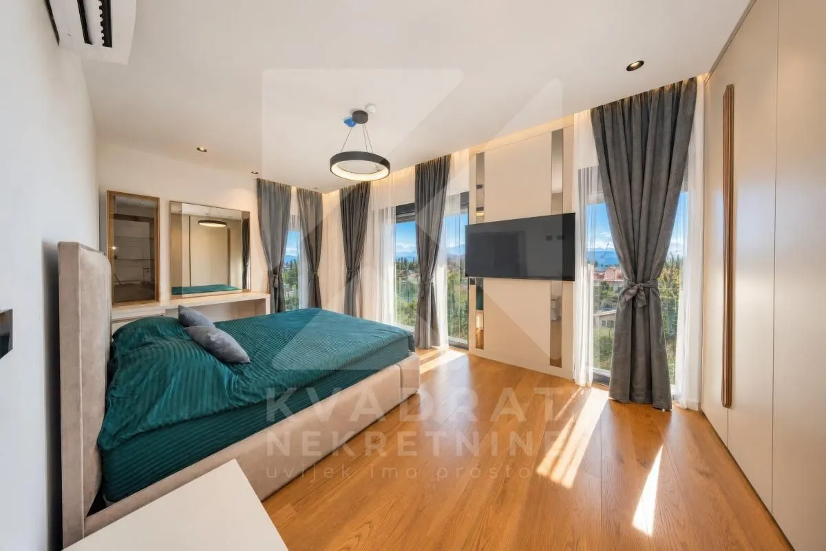 Modern bedroom with a double bed, TV, and access to the terrace.