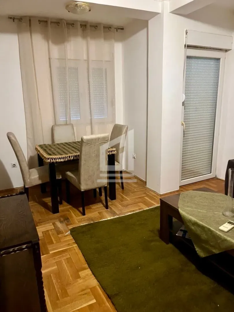 Living room with a dining table and hardwood flooring.