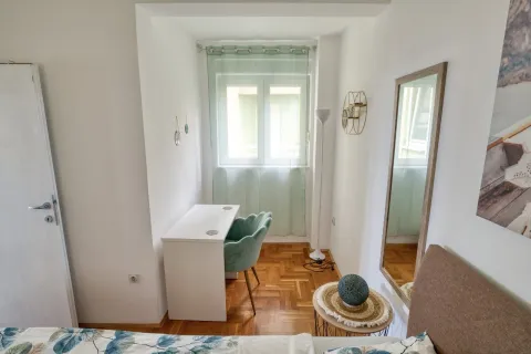 Small bedroom with a desk and a window. - image 14