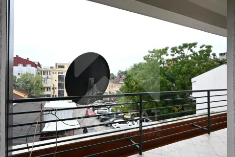 View from the balcony overlooking surrounding buildings and parking lot. - image 11