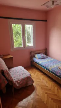 Manja spavaća soba sa krevetom, foteljom i parketom na podu. - image 4