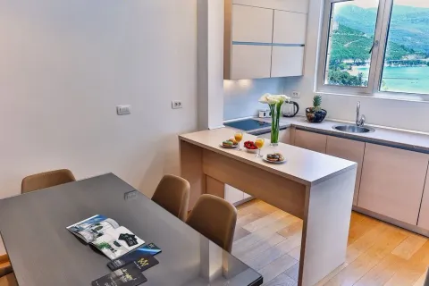 Kitchen with a breakfast bar and dining table, featuring a sea view through the window. - image 8
