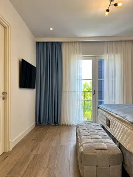 Spavaća soba sa krevetom, tapaciranom klupom i izlazom na terasu. - image 12