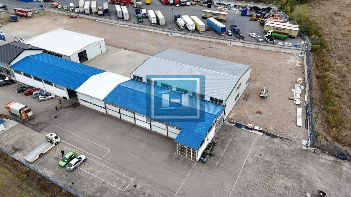 Aerial view of an industrial facility with warehouses and parking.