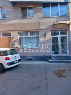 Exterior view of the commercial space with an entrance and a parked car. - image 12
