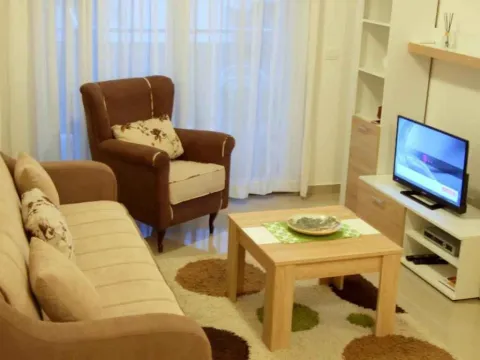 Svijetla dnevna soba sa udobnim namještajem i televizorom. - image 2