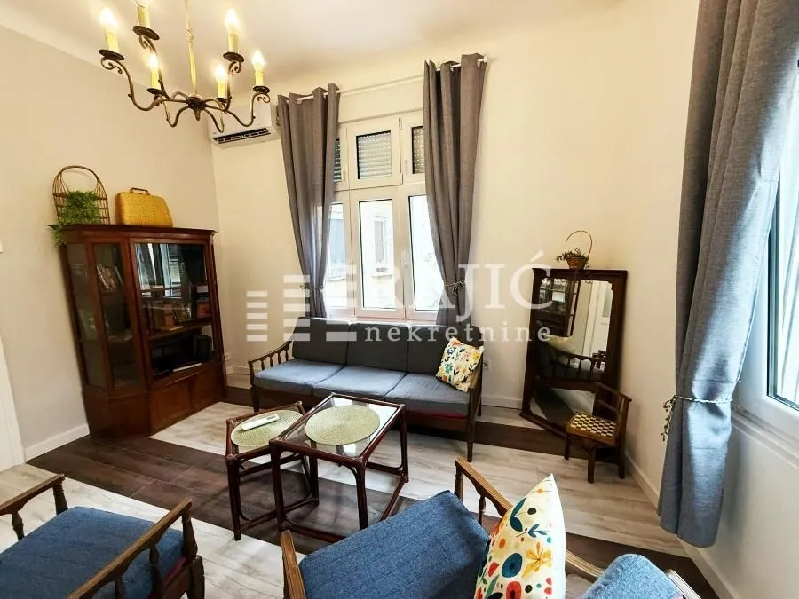 Furnished living room with sofa set and display cabinet.