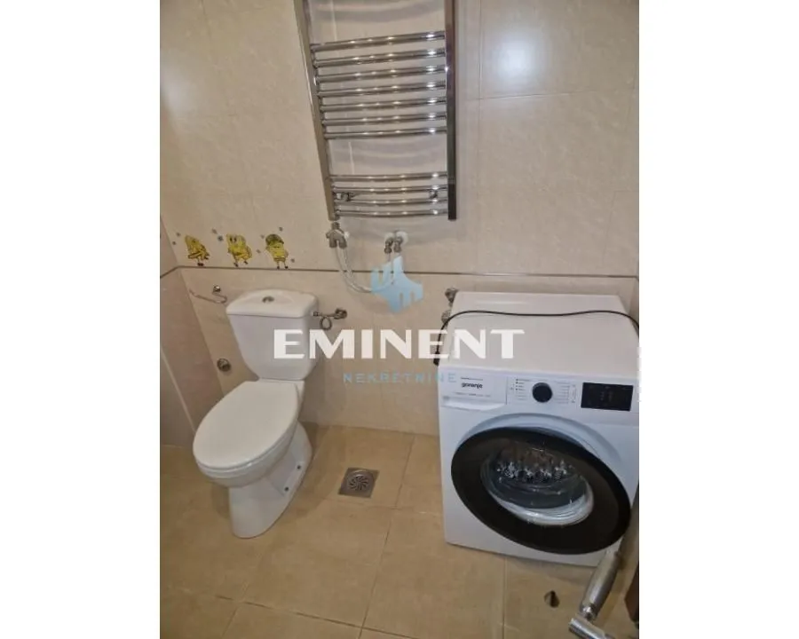 Bathroom equipped with a toilet, washing machine, and towel radiator.