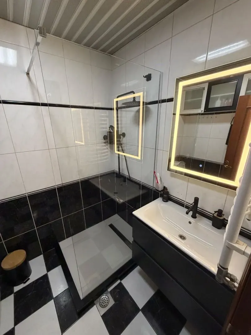 Moderne kupatilo sa tuš kabinom i umivaonikom.