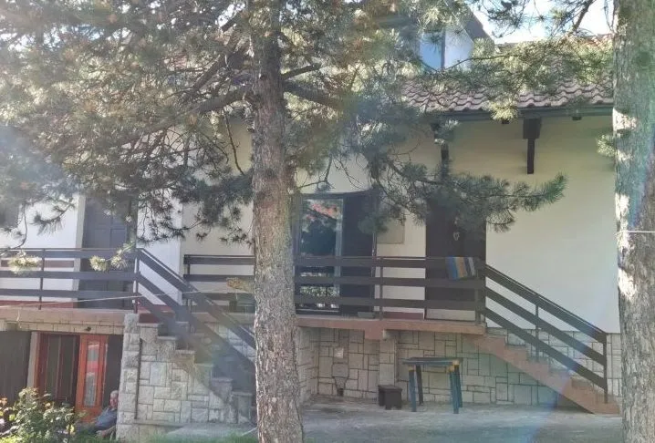 Eksterijer kuće sa dvorištem i stepeništem.