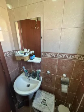 Smaller bathroom with a washbasin, mirror, and toilet elements. - image 8