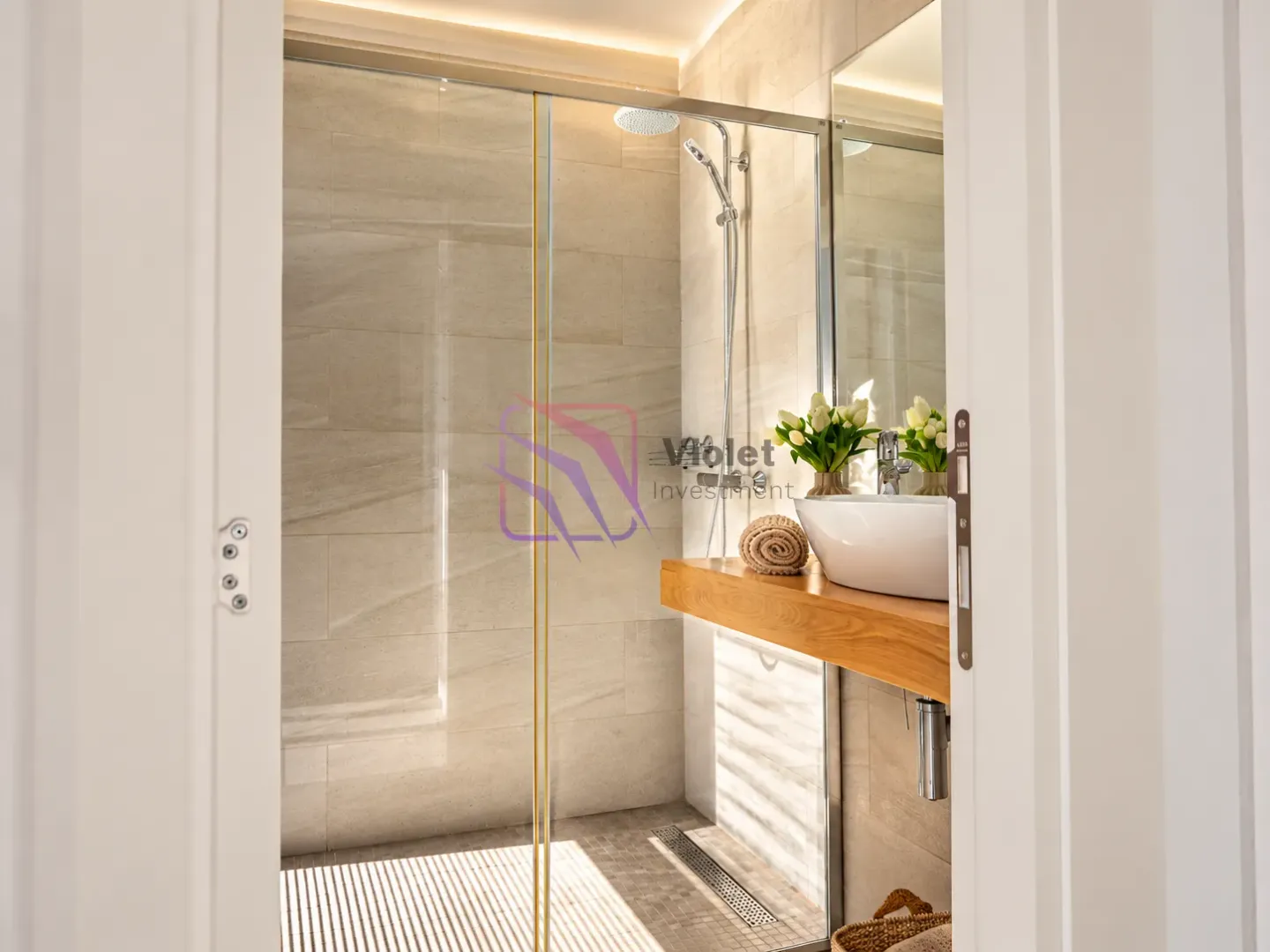 View from the hallway into a modern bathroom with a walk-in shower.