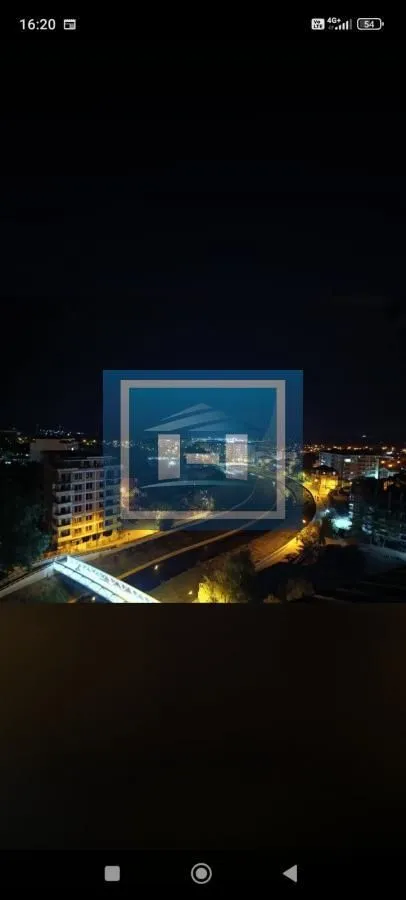 Night view from the window overlooking the illuminated city and surroundings.