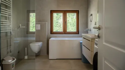 Moderne opremljeno kupatilo sa kadom, tuš kabinom i prozorom. - image 7