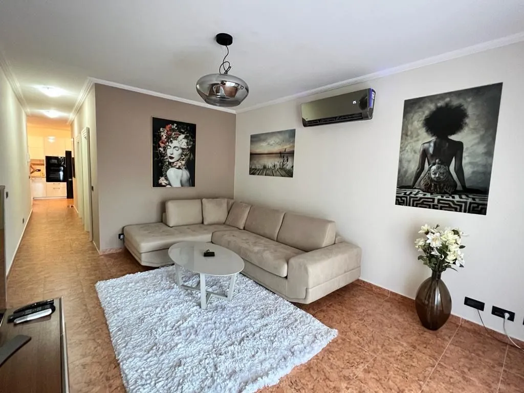 Living room with a sectional sofa, rug, and wall art.