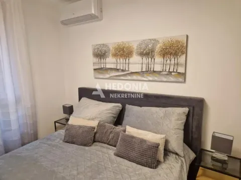 Furnished bedroom with a double bed, bedside tables, and an air conditioner. - image 8