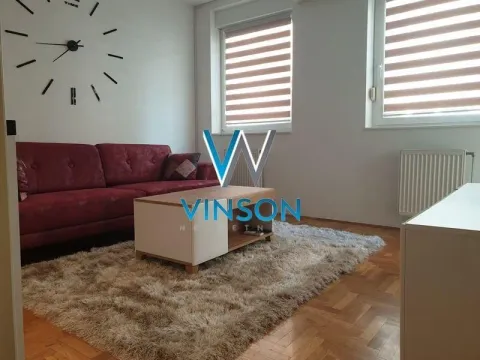 Dnevna soba sa crvenom sofom, klub stočićem i velikim zidnim satom. - image 3