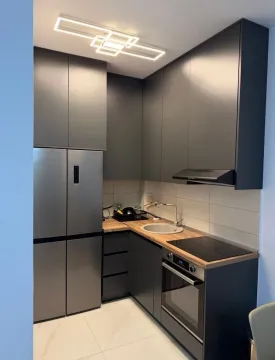 Moderna kuhinja sa tamnim elementima, ugradnom tehnikom i velikim frižiderom. - image 3