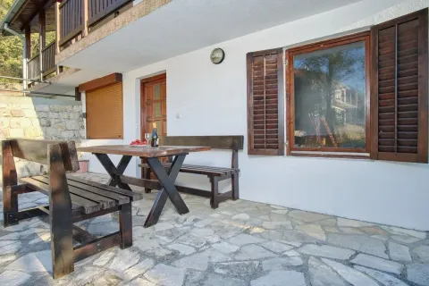 Terrace with a wooden table and benches in front of the house. - image 5