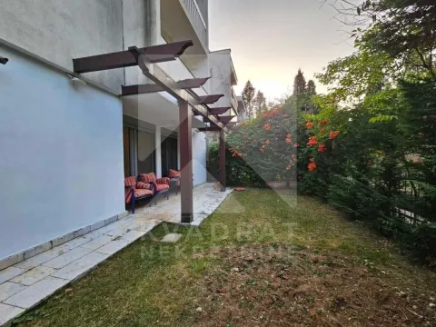 Pogled na popločanu terasu sa drvenom pergolom i uređenim dvorištem. - image 4