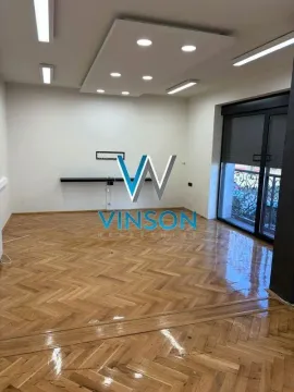 Empty room with parquet flooring and a drop ceiling with recessed lighting. - image 2