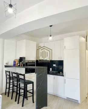 Modern white kitchen with a breakfast bar and bar stools. - image 5