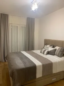 Decorated bedroom with a double bed and a window with curtains. - image 3
