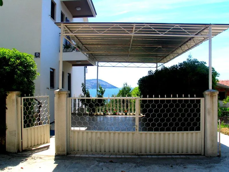 Dvorište kuće sa nadstrešnicom, kapijom i pogledom na more.