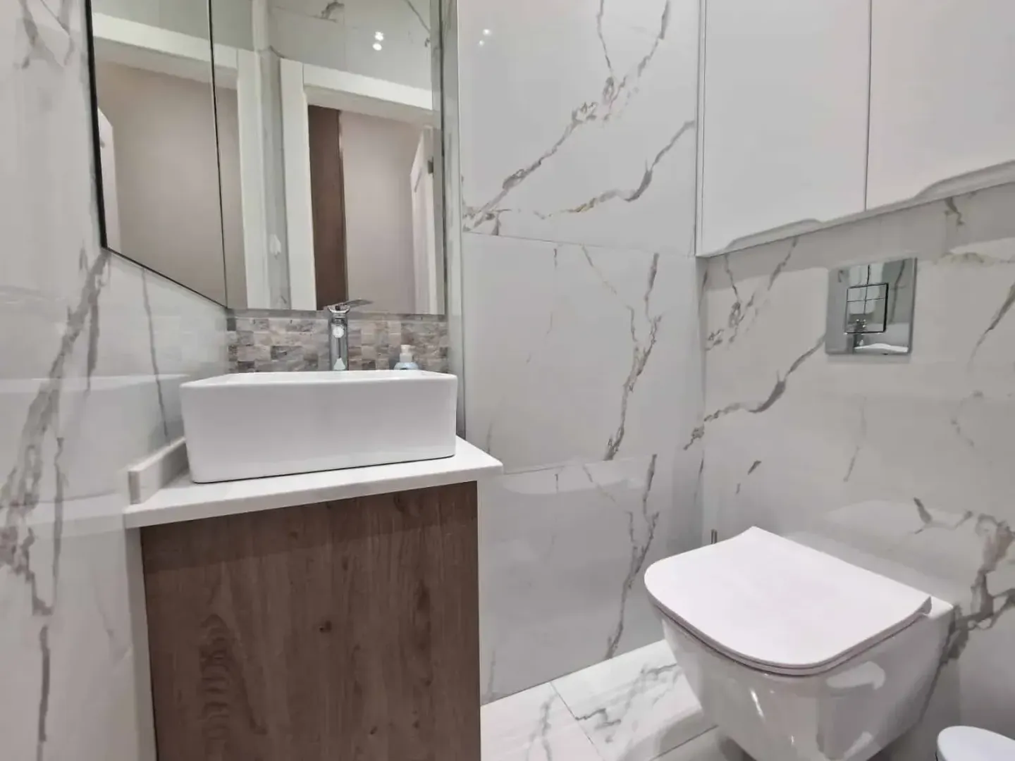 Modern bathroom equipped with a washbasin and a wall-hung toilet.