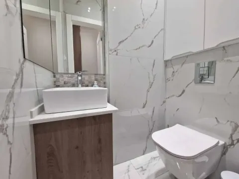 Modern bathroom equipped with a washbasin and a wall-hung toilet. - image 11
