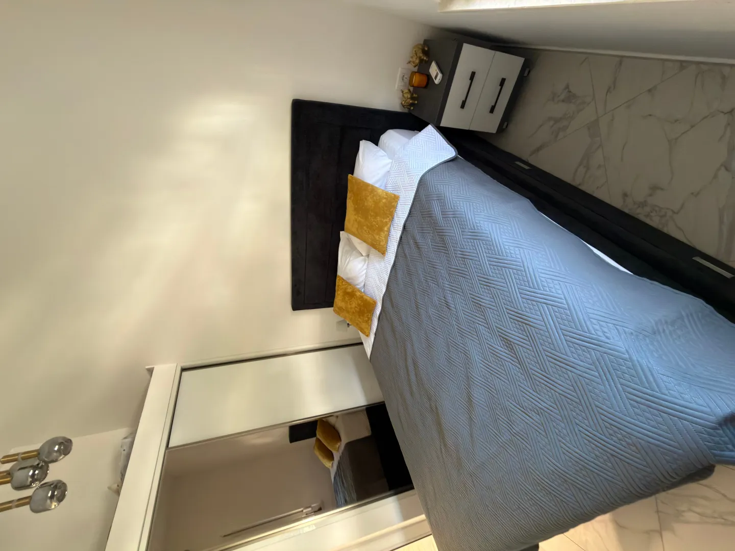 Modern bedroom with a double bed, wardrobe, and nightstand.
