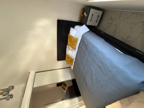 Modern bedroom with a double bed, wardrobe, and nightstand. - image 4