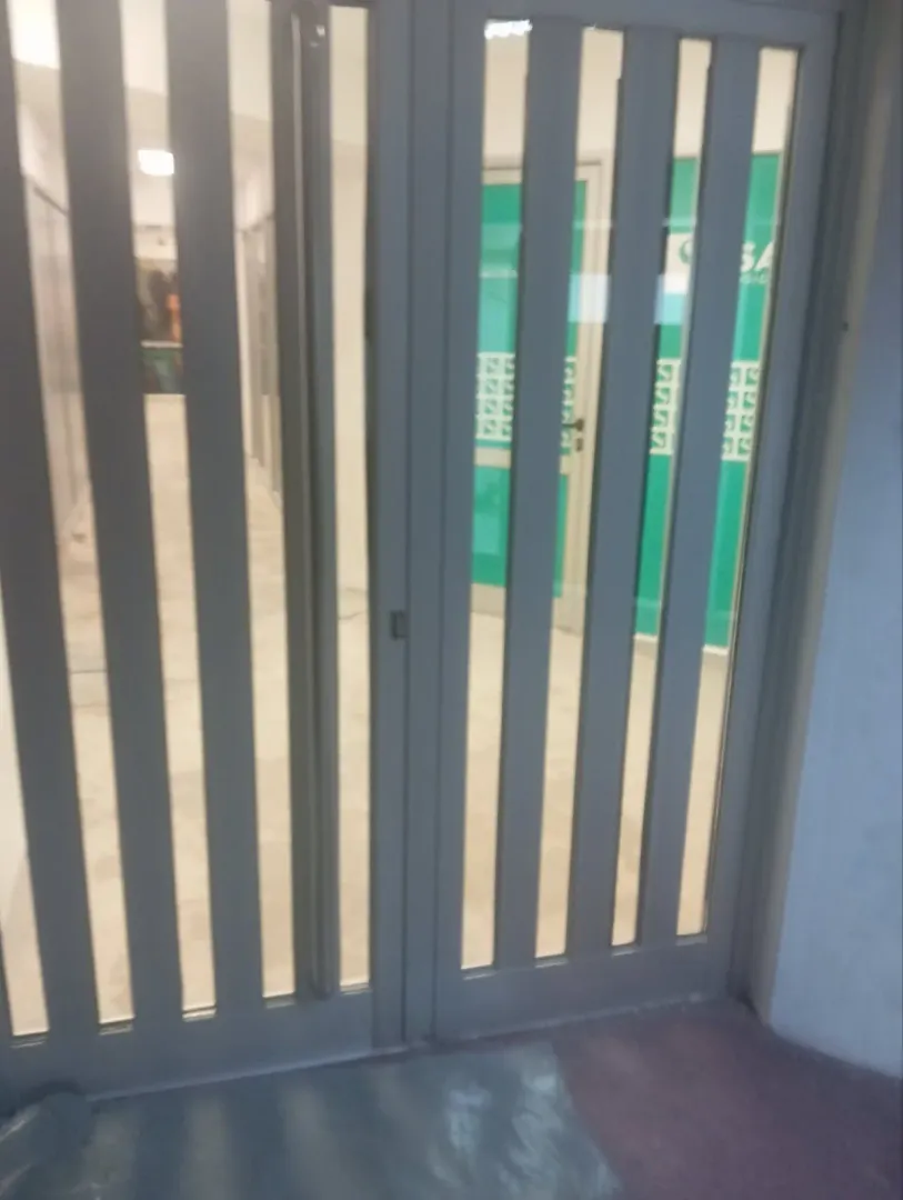 An entrance door with a metal grate at the building entry.