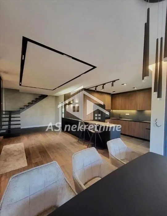 Modern kitchen with a bar counter and dining table in an open-plan space.