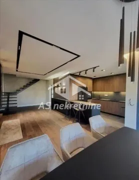 Modern kitchen with a bar counter and dining table in an open-plan space. - image 10
